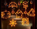 Halloween battery-powered LED window lights with spider, pumpkin and ghost figures hung by suction cups.