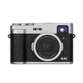 Black 5K digital camera with front and rear lenses, optical viewfinder, and 2.88-inch screen on a strap.