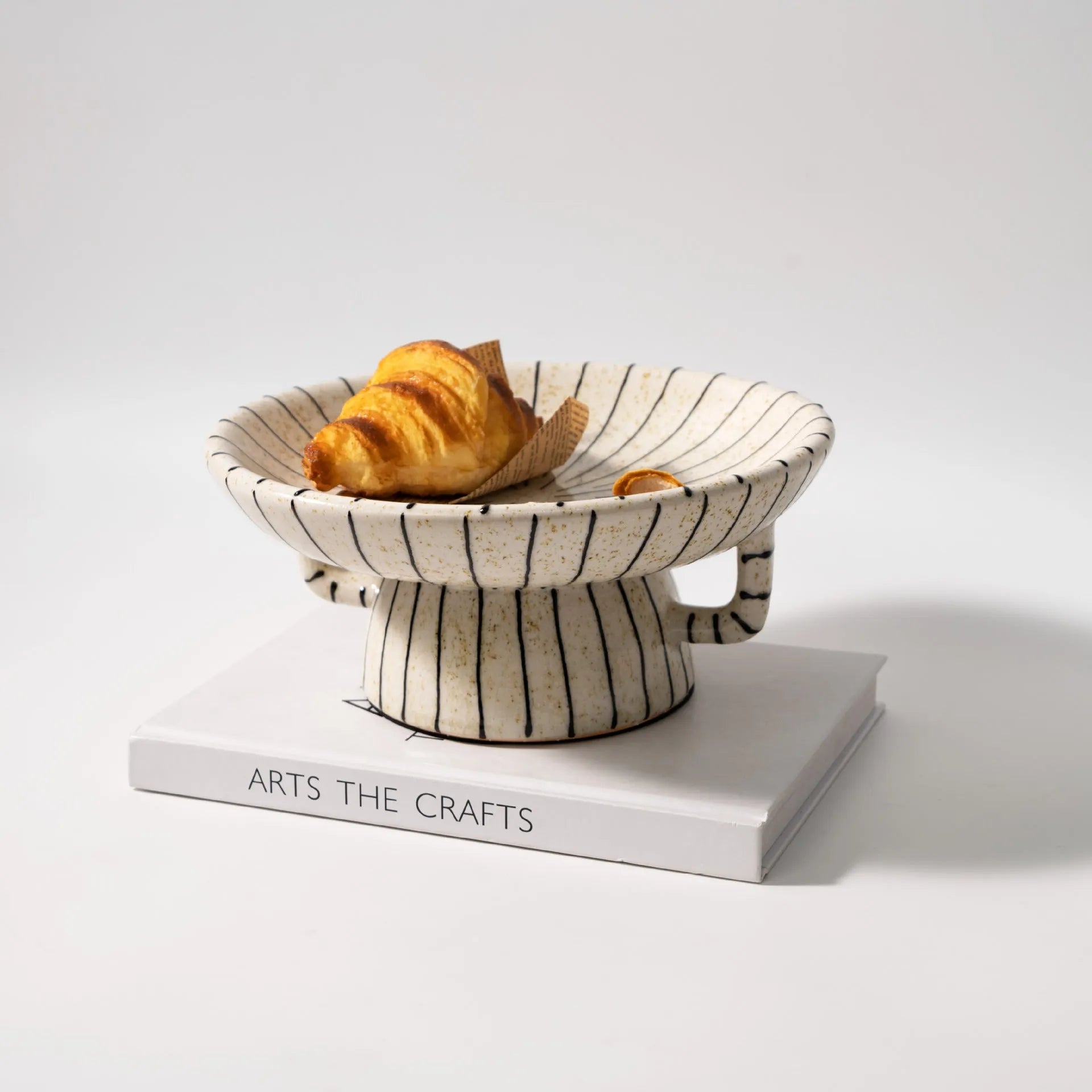 Black and white striped synthetic resin fruit plate on a table