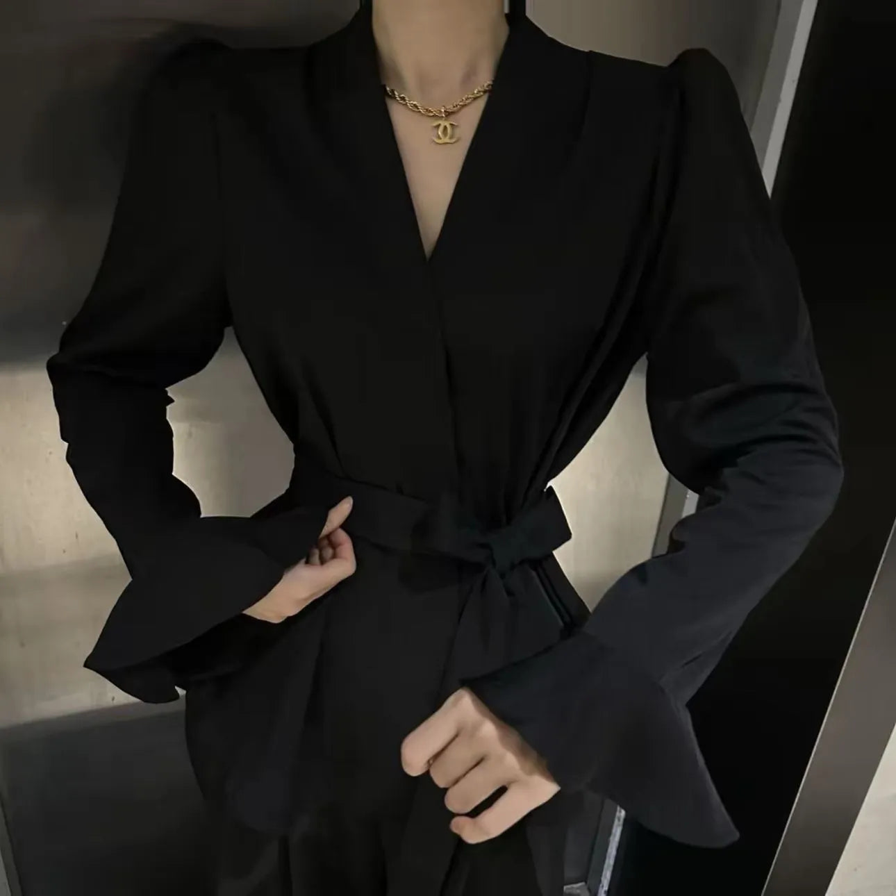 Black women's French-style shirt with irregular collar, long bell sleeves and tied front detail.