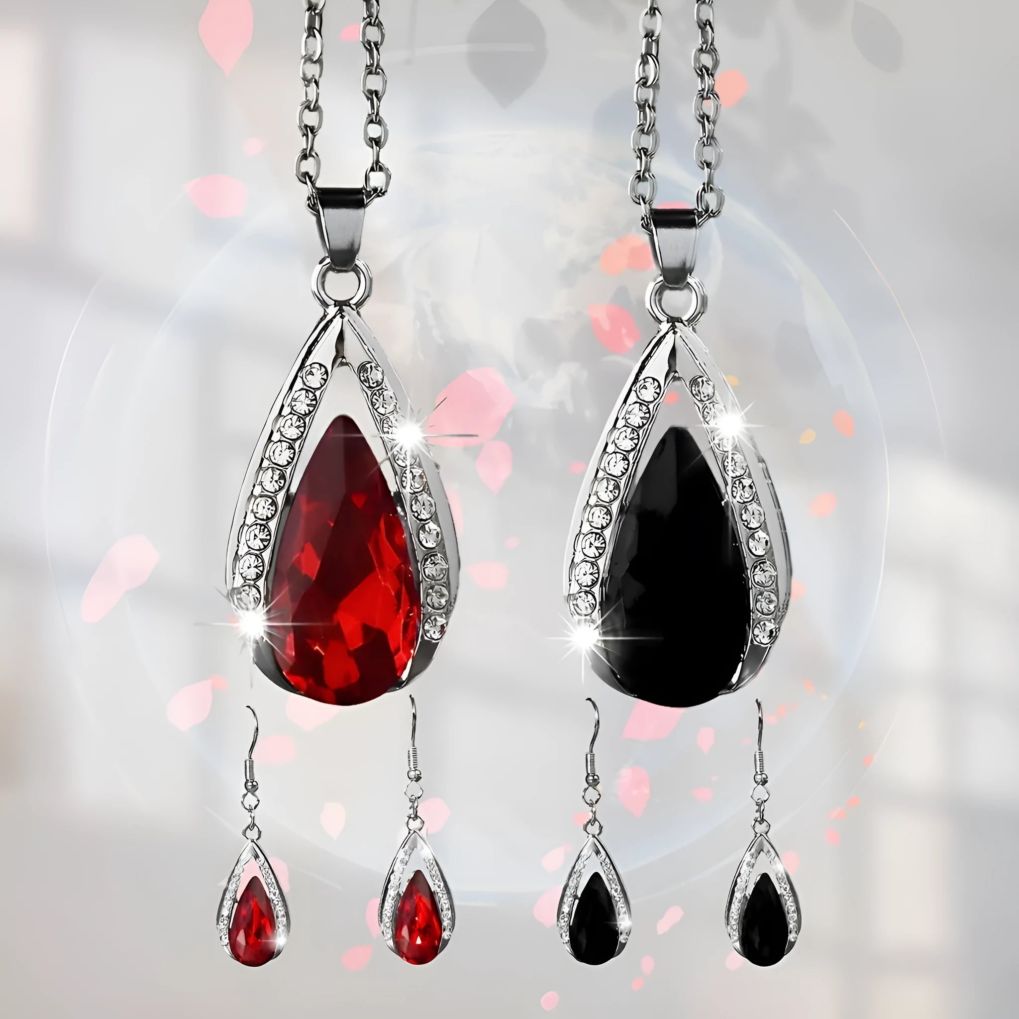 Black and red teardrop-shaped glass pendant necklace and matching earrings set laid flat.
