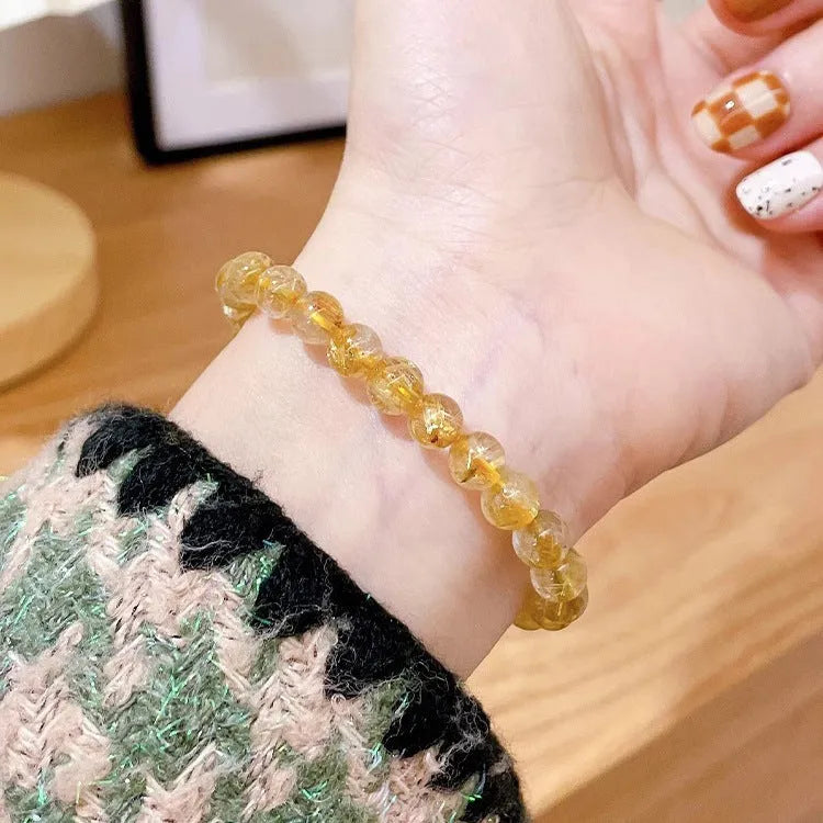 Handcrafted natural gold rutilated quartz sunstone bracelet with diamond-shaped and round crystal beads for women