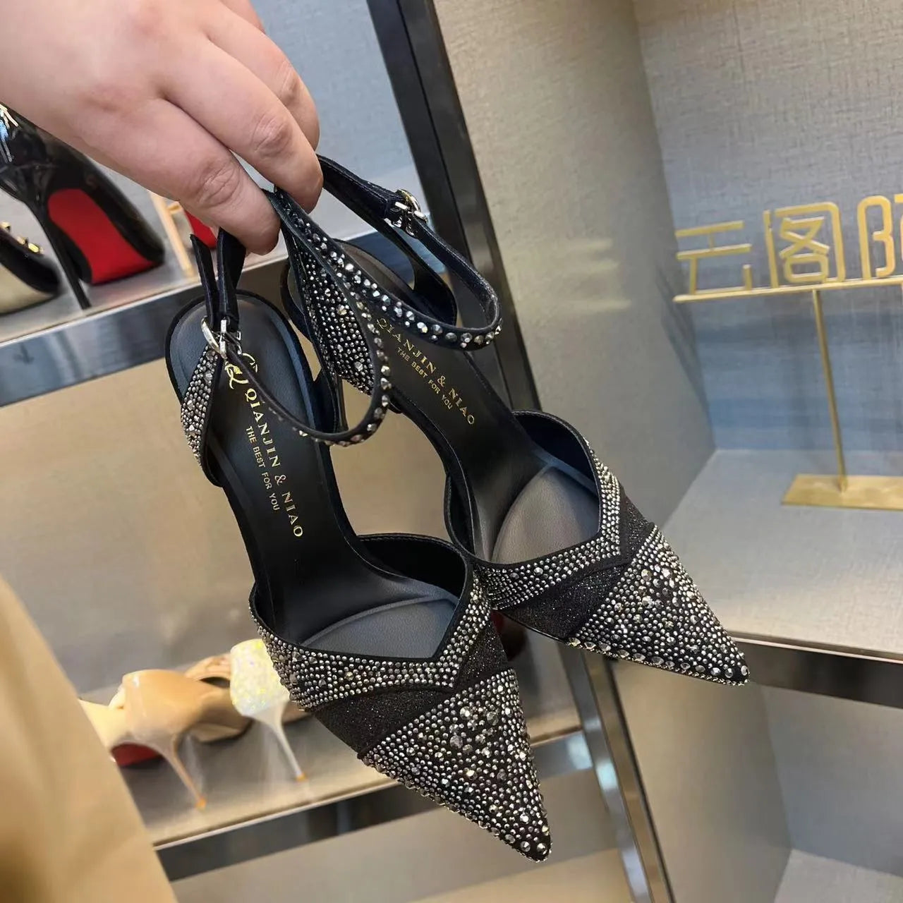 Women's black high heels with hollow red stiletto heel and pointed toe.