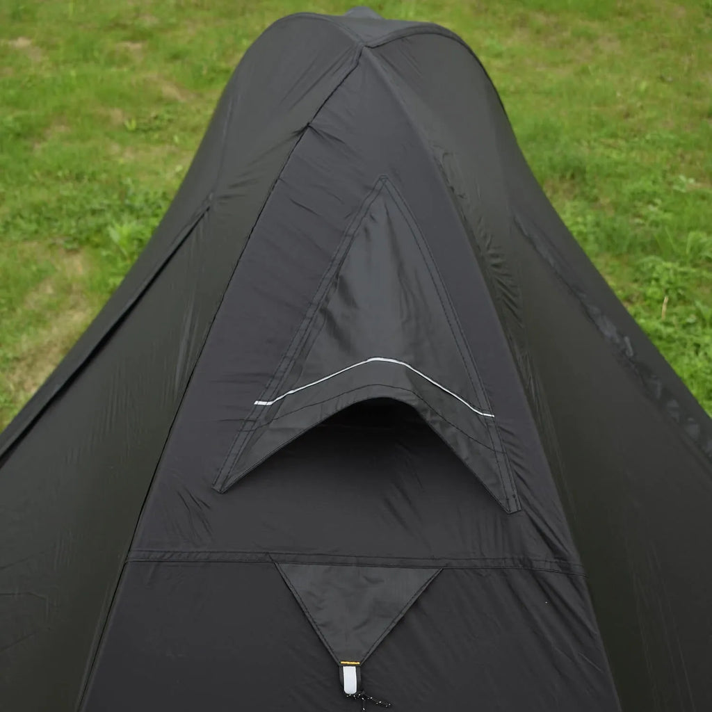 Single person orange double-layer hiking tent pitched in a field with aluminium poles visible.