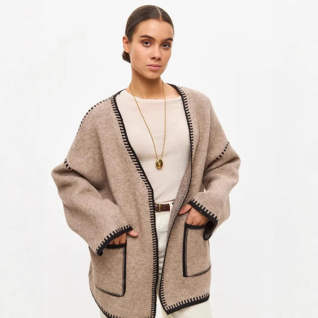 Lace-up front knitted cardigan in a camel colour, shown loose and open over a top.