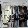 Women's light brown wool blend knit cardigan, vest, and trousers three-piece set laid flat.