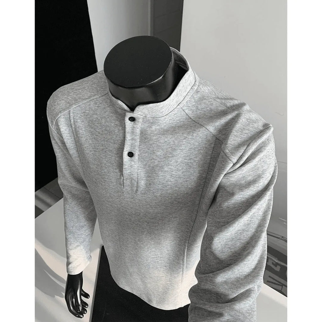Man wearing a grey patchwork shoulder polo shirt with a stand-up collar and long sleeves.