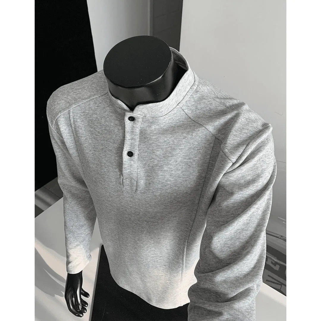 Man wearing a grey patchwork shoulder polo shirt with a stand-up collar and long sleeves.