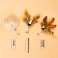 Three steel wire cat toy replacement heads with small flying insect designs on a plain background.