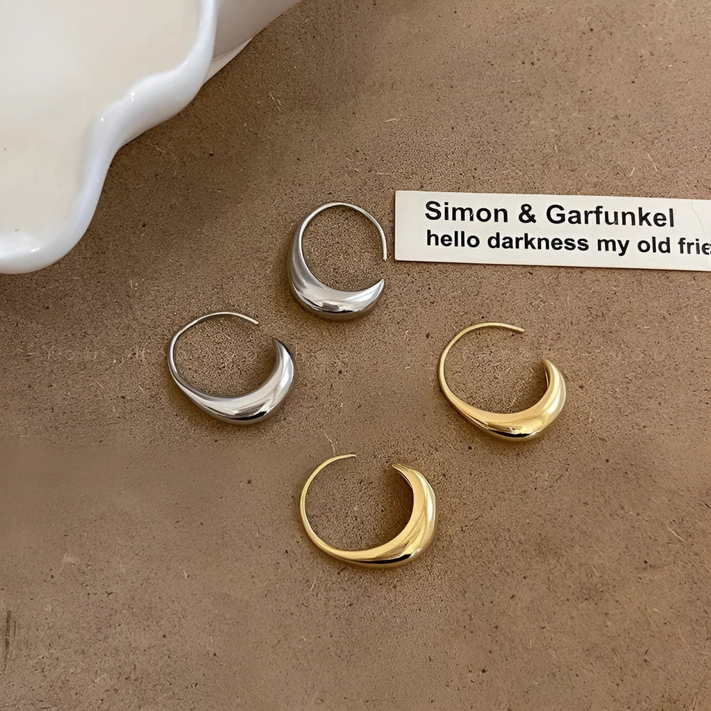 Teardrop hoop earrings in gold or silver tone alloy with C-shaped geometric design, one pair