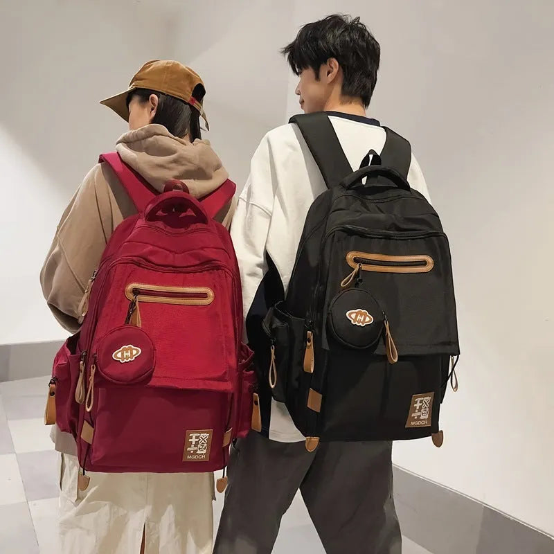 Large-capacity black nylon school backpack for junior high students with a curved shoulder strap.