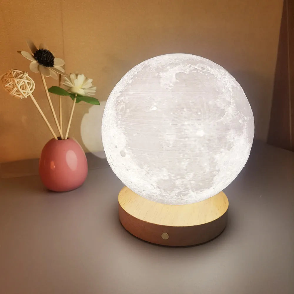 Rotating moon night light on wooden base showing three colour options and size scale