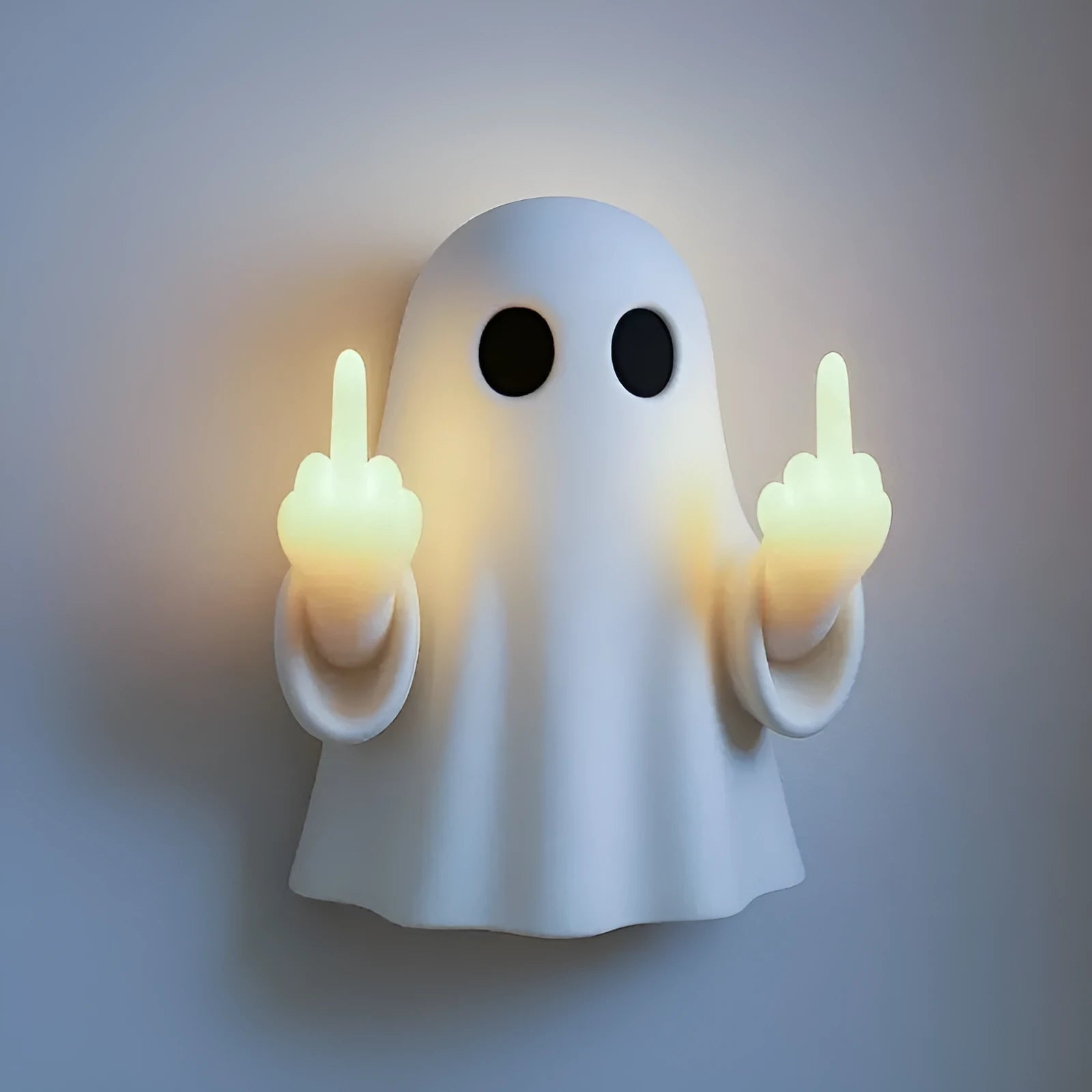 White plastic ghost statue night lamp for Halloween decoration on a dark surface.