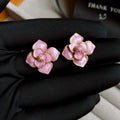 A pair of gold-plated flower stud earrings with a detailed purple oil-spot glaze finish on the petals.
