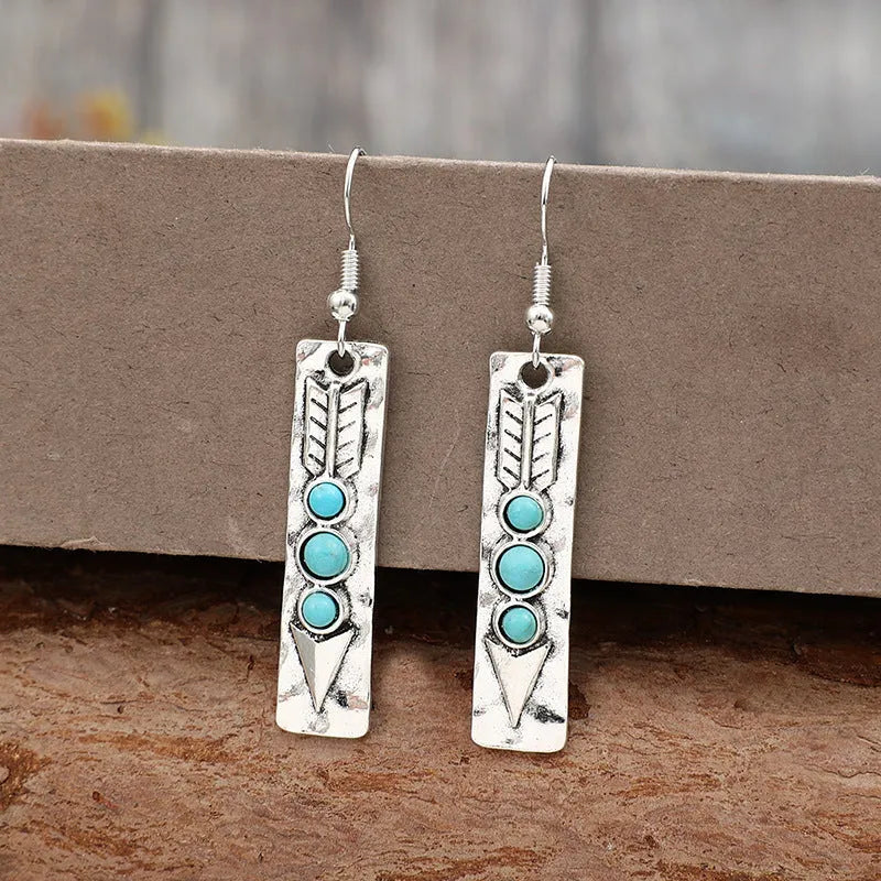 Silver long strip geometric earrings with turquoise inlay, showing front view.