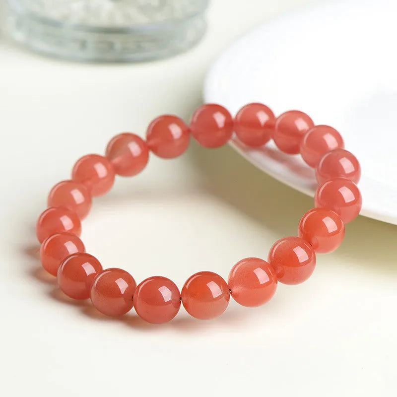 Natural cherry red agate beaded bracelet showing polished stones on a wrist, demonstrating single and triple strand options.