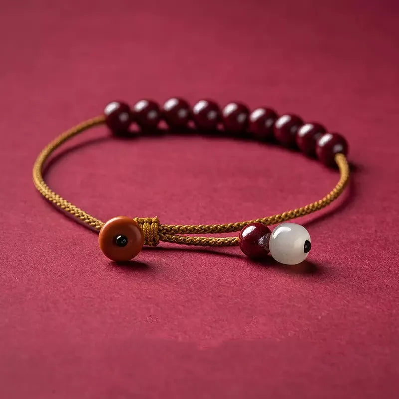 Hand-woven cinnabar bracelet with geometric design showing natural mineral colours