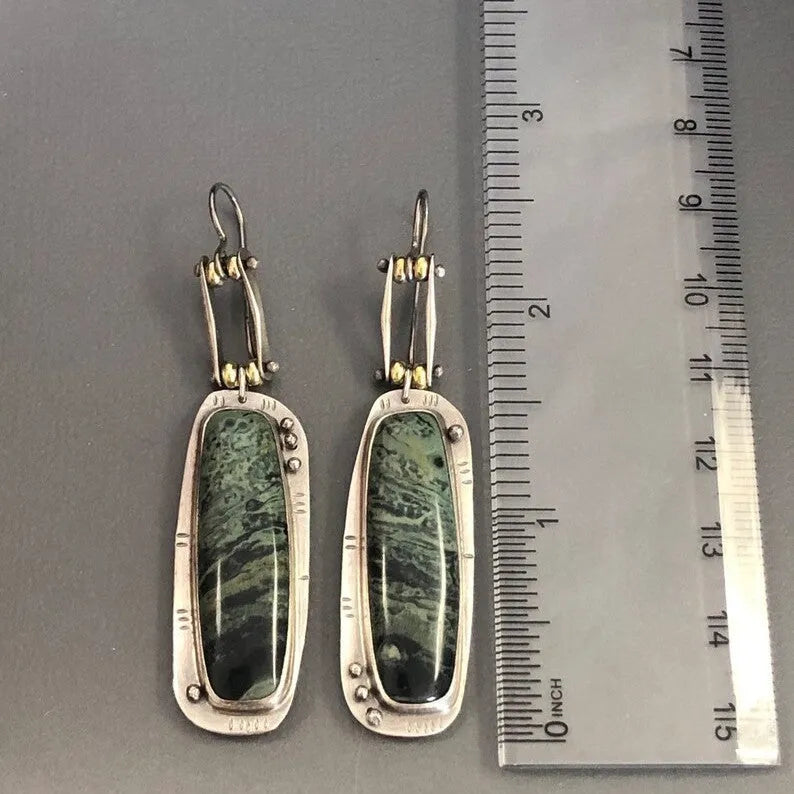 Geometric alloy earrings with a two-colour marble pattern on a white background.