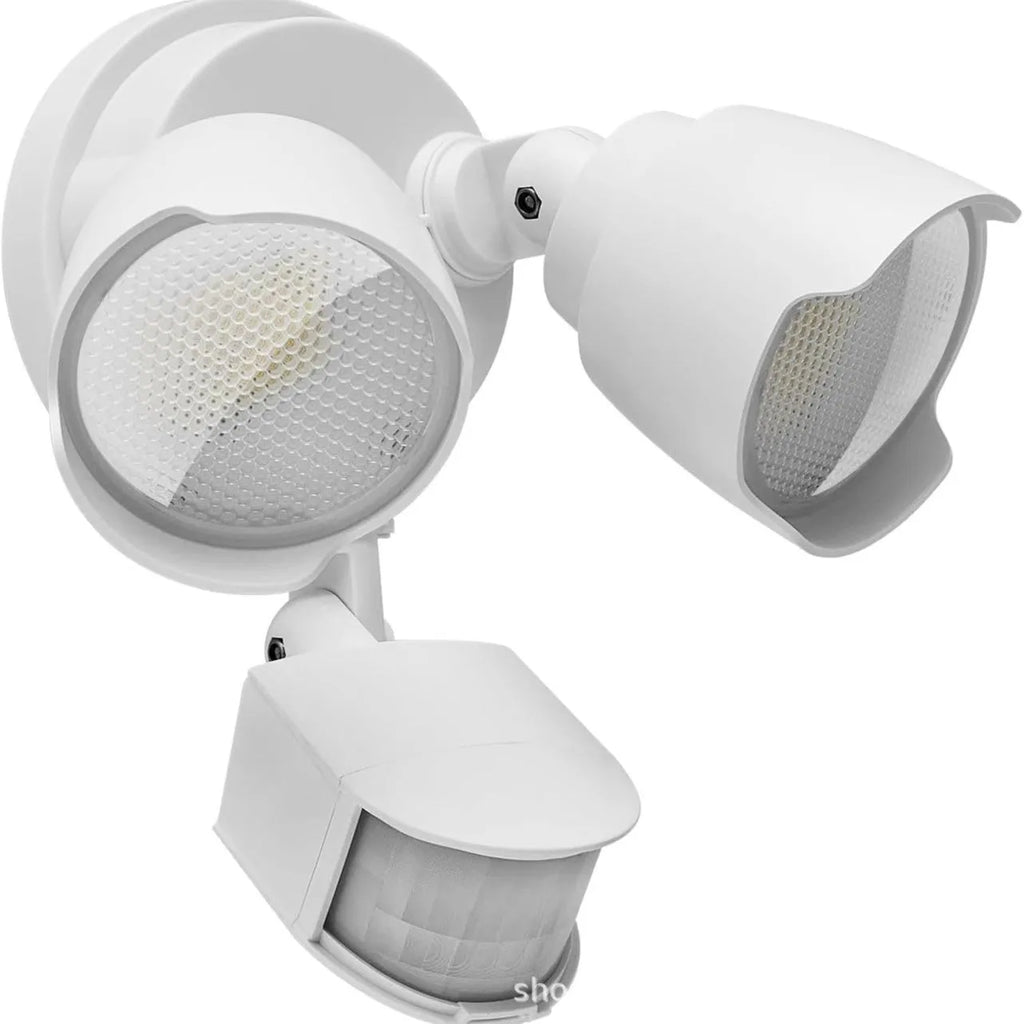 White outdoor LED security flood light with motion sensor mounted on a wall bracket