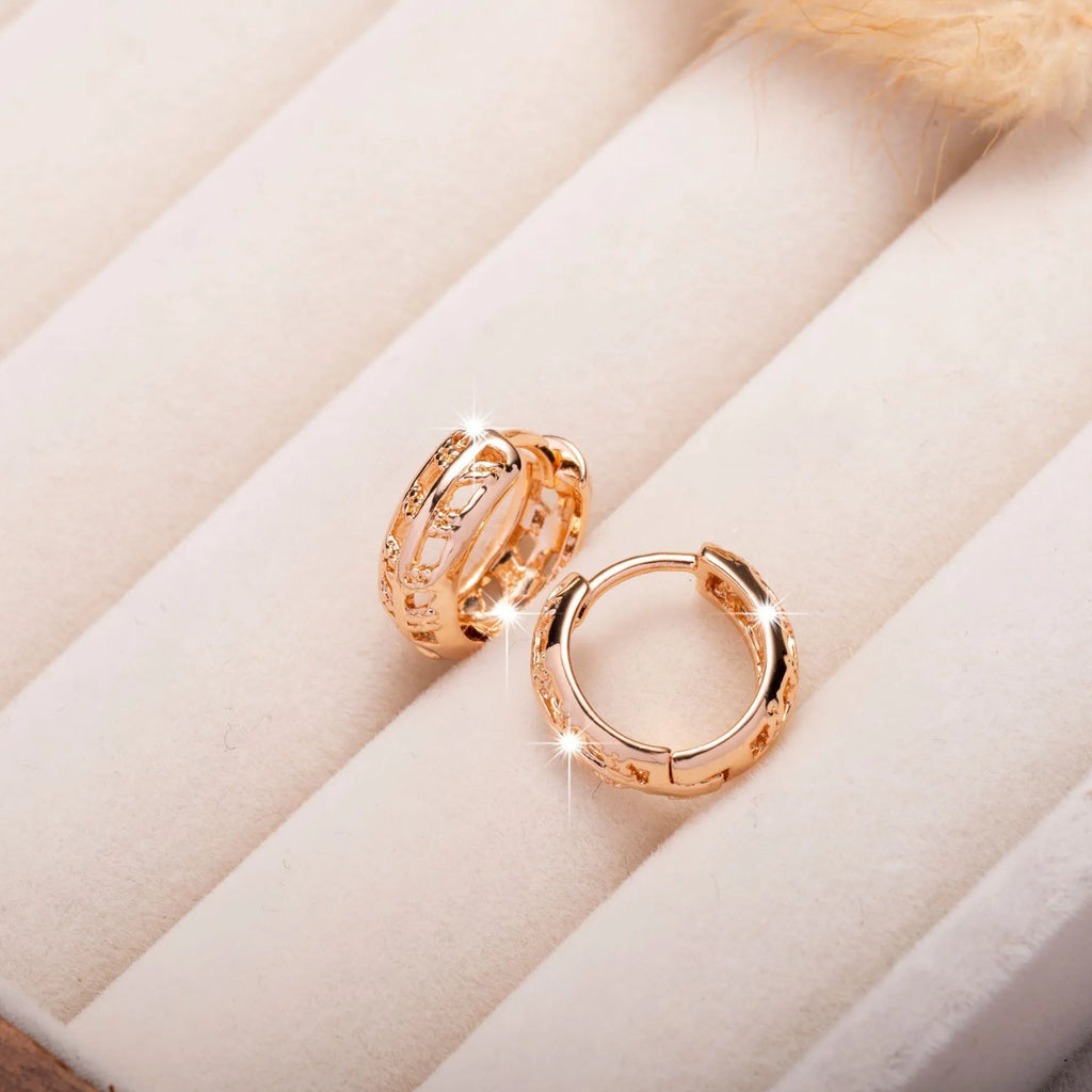 Rose gold plated hollowed-out heart and leaf shaped earrings on a white background.