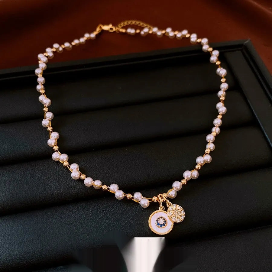 Gold electroplated necklace with round zircon and imitation pearl geometric pendant on an adjustable chain.