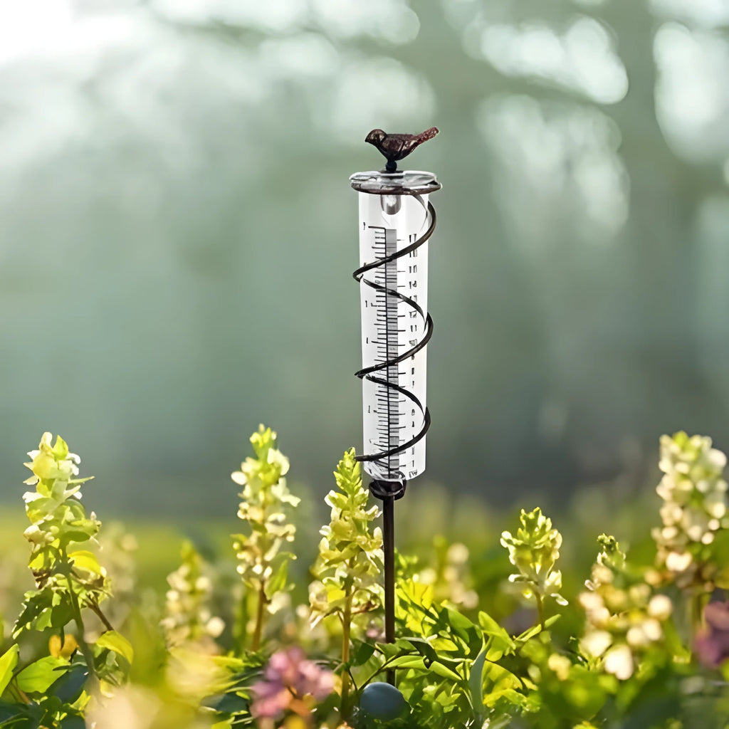 Cast iron outdoor garden rain gauge with hummingbird decoration and measurement scale.