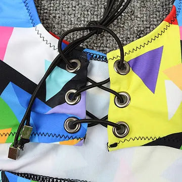 Women's checkered multicolour bikini set with cross-strap fishnet top and high-waist briefs.