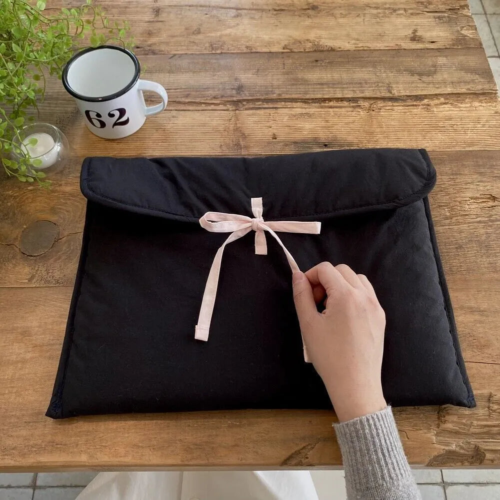 Black and white women's quilted nylon laptop bag with a ballet-style bow.