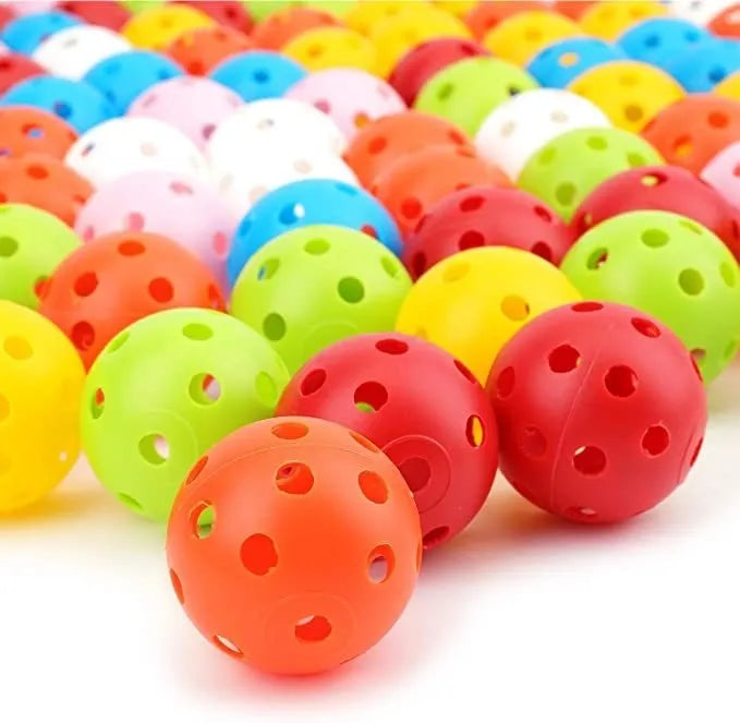 Assorted brightly coloured golf practice balls in red, orange, blue, green, white and yellow on a net.