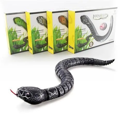 Green remote control snake toy with retractable tongue and swinging tail on floor