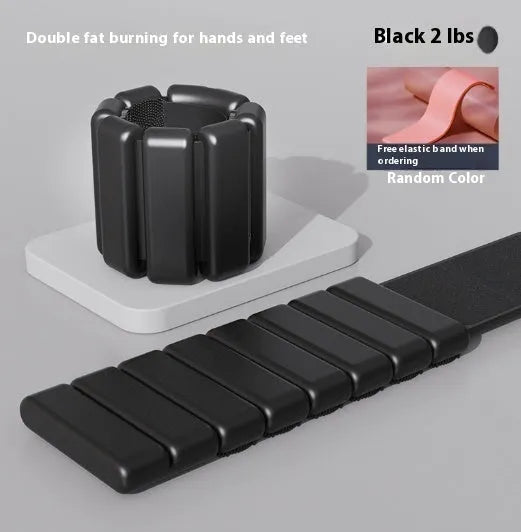 Silicone fitness wrist weight bracelet with Velcro strap in black, shown on a wrist.