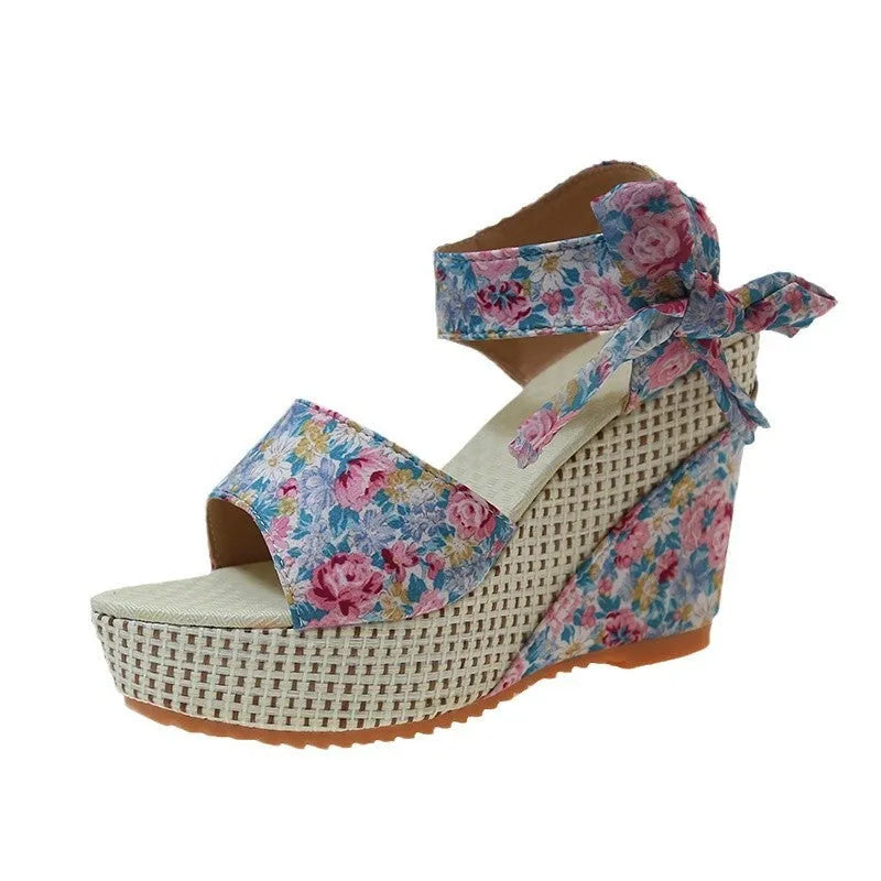 Women's wedge peep toe sandals with an ankle strap buckle in a floral pattern.