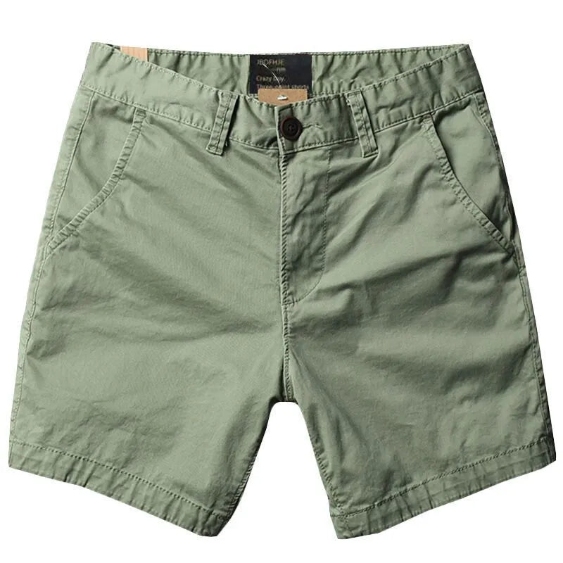 Man wearing loose-fitting solid colour cotton shorts with a zip fly and straight legs.