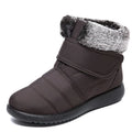 Women's winter snow boots with plush lining, suede upper, velcro strap, flat heel, and anti-skid rubber sole in black.