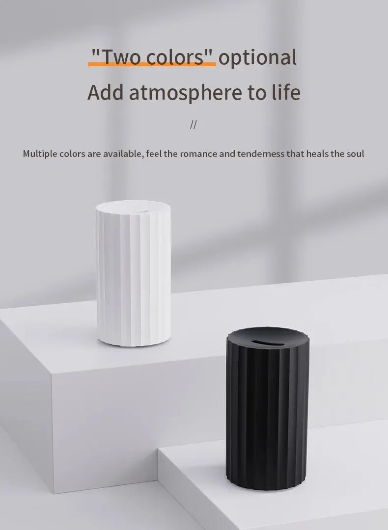 Black portable USB air humidifier and essential oil diffuser with glowing LED flame effect on a table