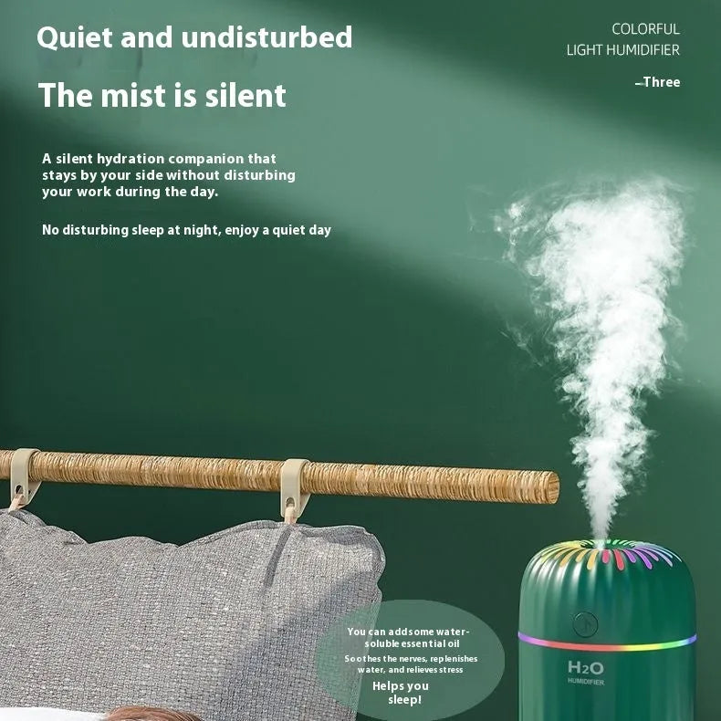 Green mini car USB aromatherapy humidifier on a desk with USB cable.