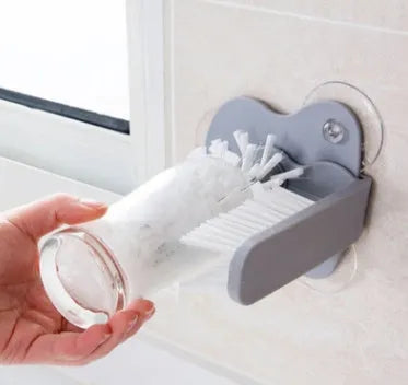 Grey rotating cup brush with dual heads and suction cups for wall mounting