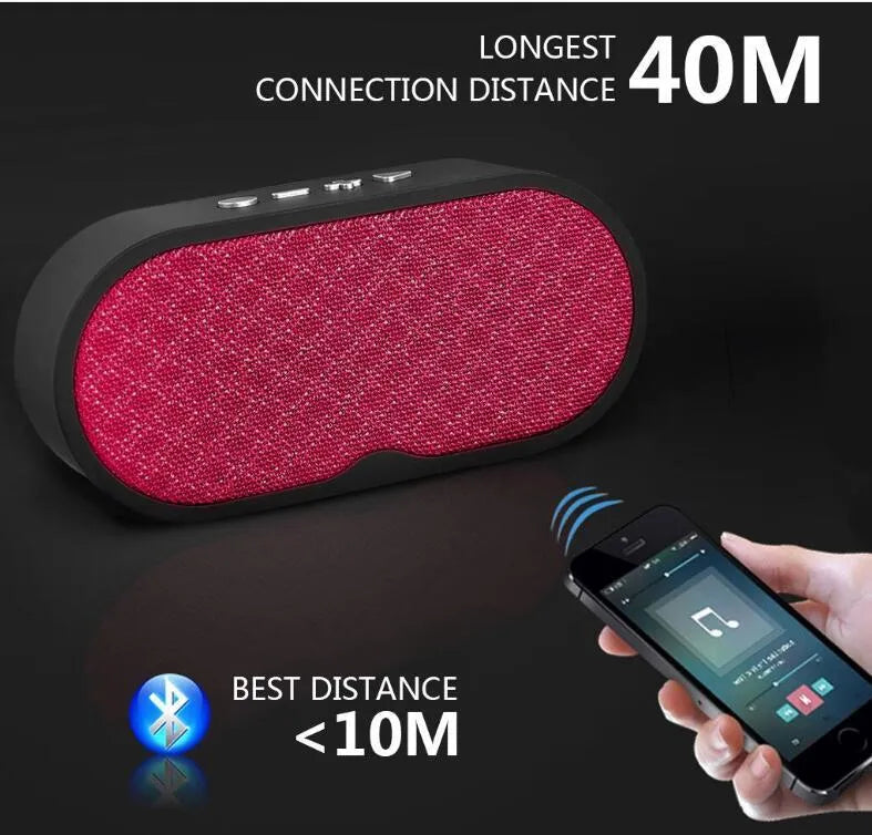 Grey portable Bluetooth speaker with TF card slot, USB port, and built-in microphone on a table.
