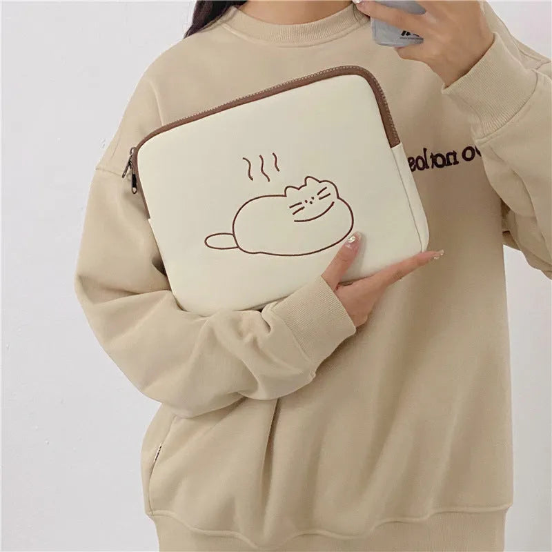 Embroidered fat cat design on a grey nylon tablet protective sleeve with a black zipper.