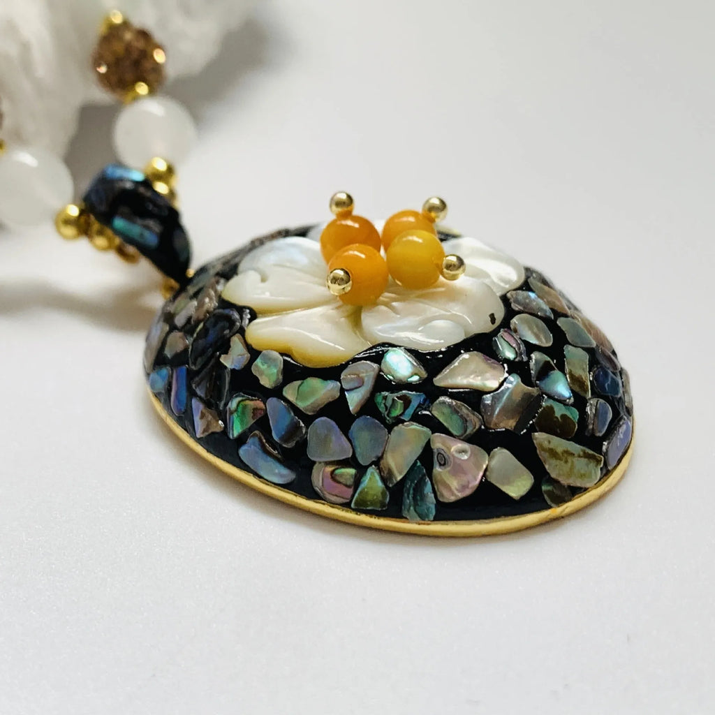 Original design mother-of-pearl lacquer shell necklace with rhinestone twist chain on display