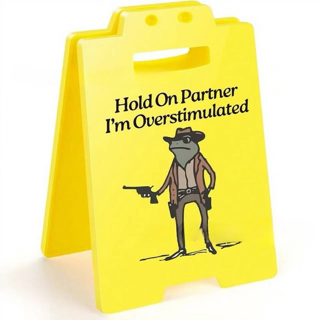 Yellow plastic humour desk ornament with 'I Am So Excited' text on a simple modern background