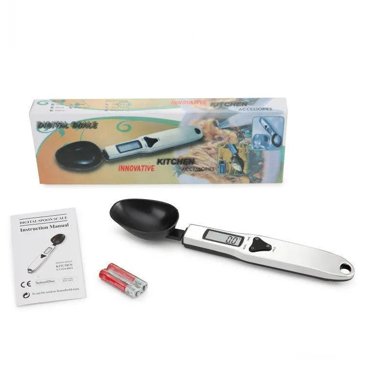 Digital smart measuring spoon with electronic display showing weight, placed on a kitchen worktop.