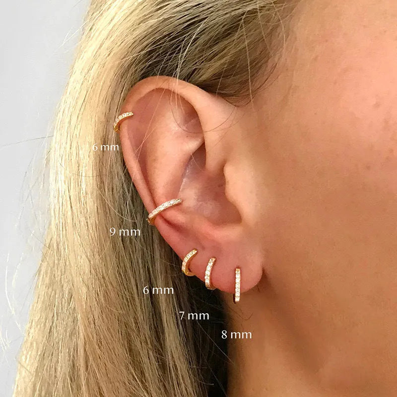 Circle-shaped cubic zirconia stud earrings in gold, rose gold, and silver colours on a white background.