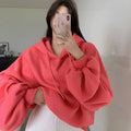 Watermelon red mulberry silk hooded sweater on a hanger, showing loose sleeveless fit.