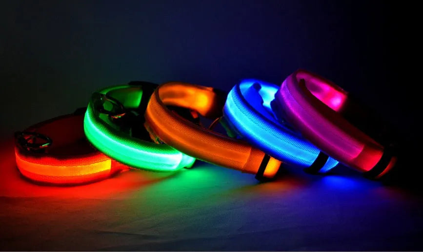 Nylon LED pet collar with adjustable buckle in blue, glowing with fibre optic lights in flash mode on a dark surface