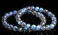 Polished natural cream body blue moonlight crystal bracelet on a wrist, showing simple bead design.