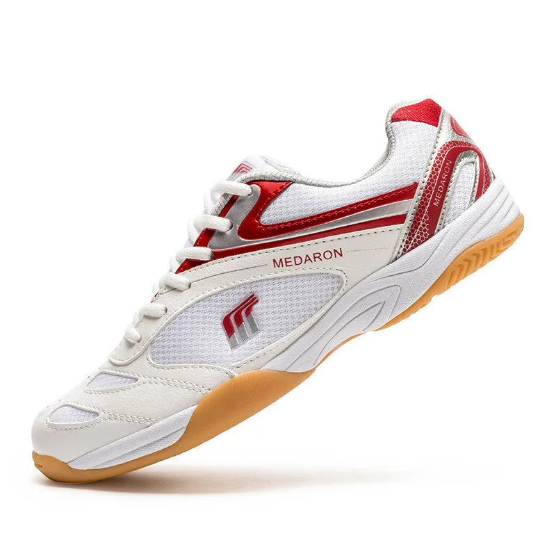 White table tennis sneakers with red accents, showing mesh panels, lace-up front, and rubber outsole.