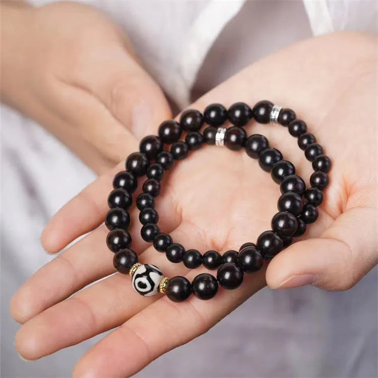 Close-up of Tibetan-style ebony wood bead bracelet showing 8mm diameter beads in two-circle layered design