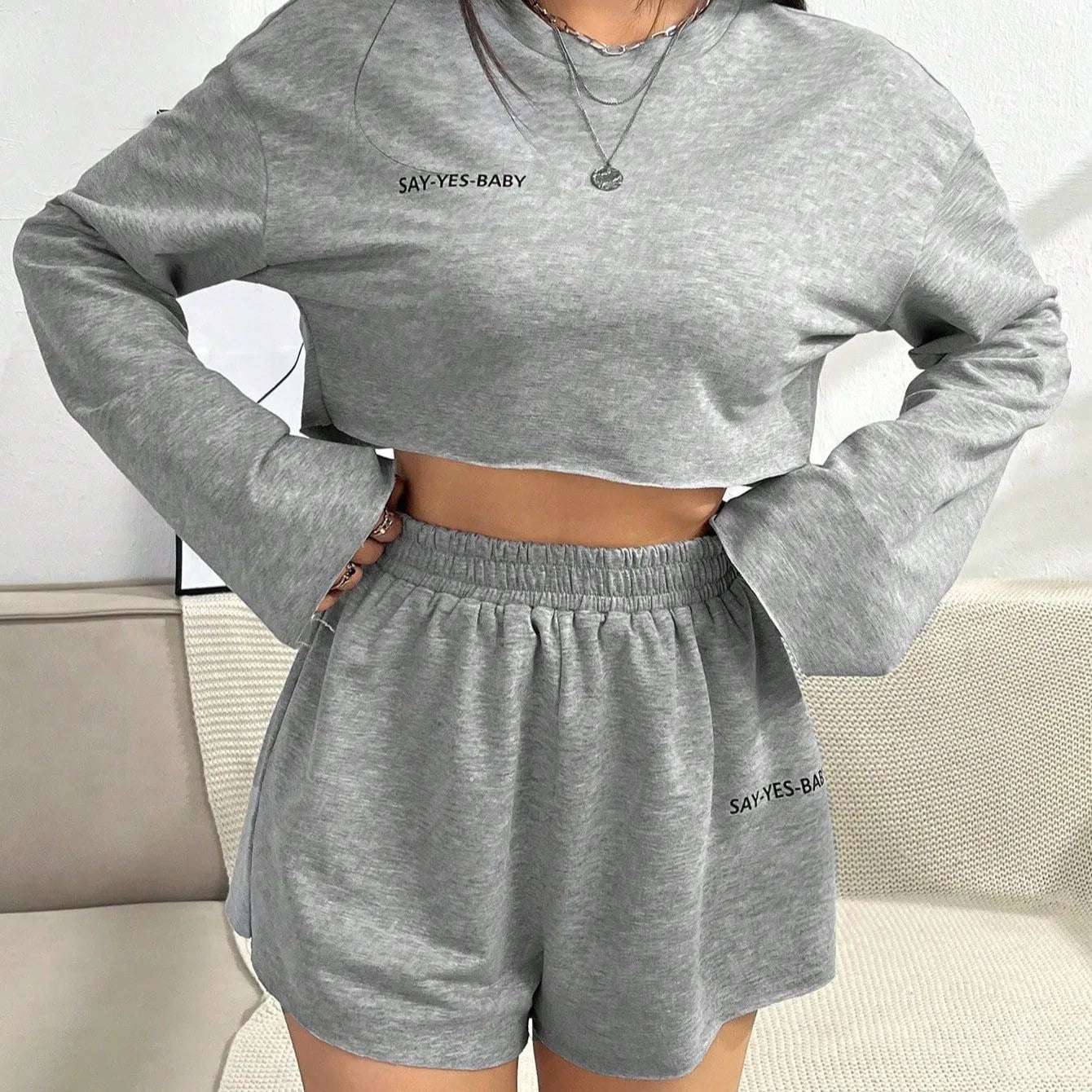 Grey women's long-sleeved t-shirt and matching shorts co-ord set laid flat.