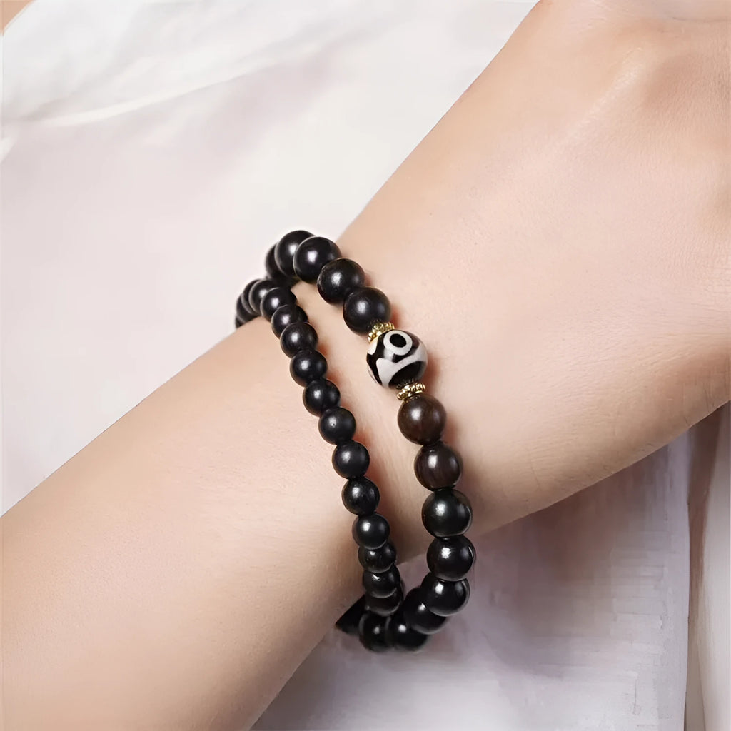 Close-up of Tibetan-style ebony wood bead bracelet showing 8mm diameter beads in two-circle layered design